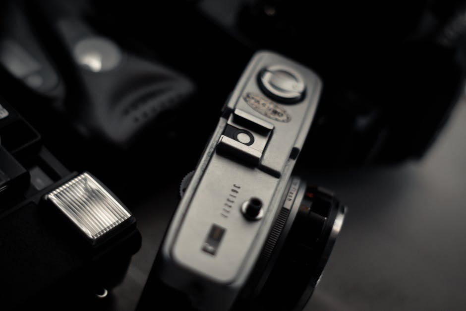 5 Gründe, warum Sie Ihre alten Negative jetzt digitalisieren sollten: From above of retro photo camera with buttons near flash on desk in flat From Above Of Retro Photo Camera With Buttons Near Flash On Desk In Flat